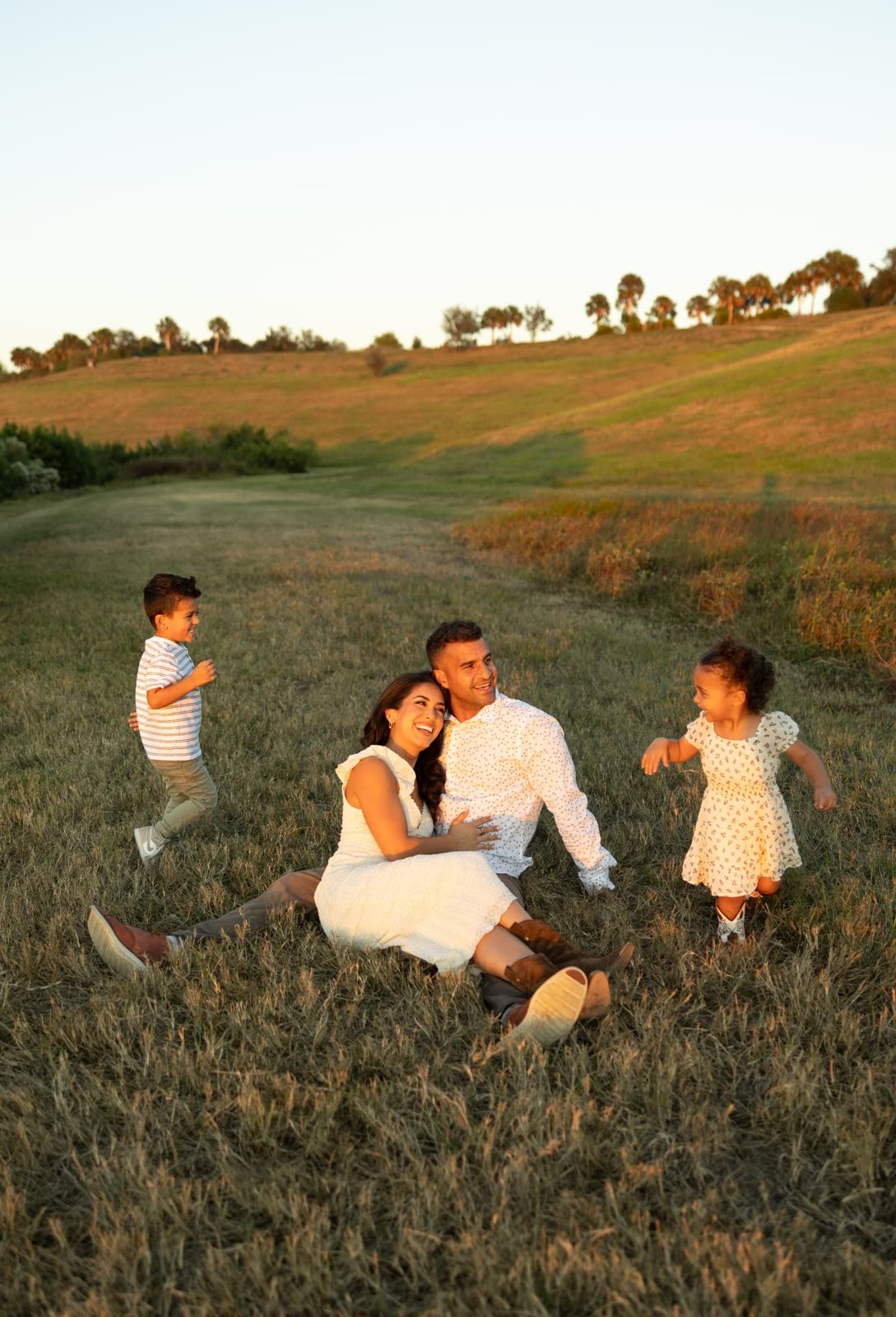 Rebecca Vargas with her family in a golden field at sunset