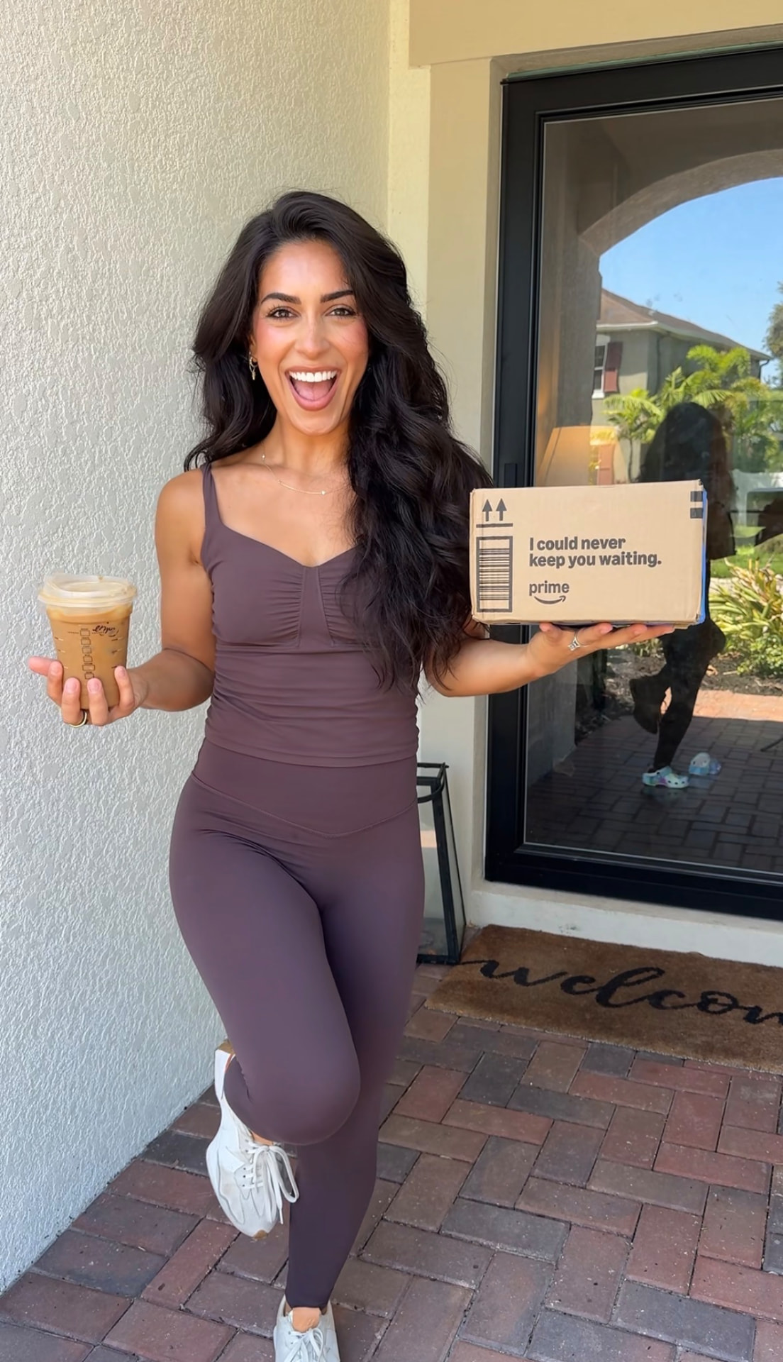 Rebecca Vargas smiling with an Amazon package and iced coffee